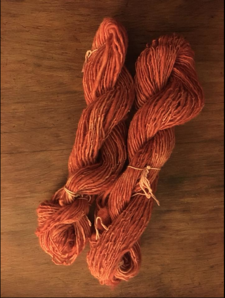 Two skeins of pale red wool yarn